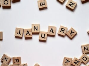 Close-up of Scrabble tiles spelling 'January' on a white surface, perfect for winter or new year themes.