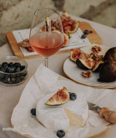 pexels-photo-12991635-12991635 A rustic setup of brie cheese, figs, and rose wine, perfect for a gourmet snack.