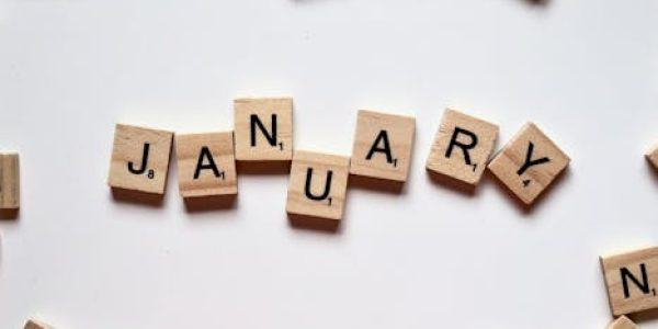 Close-up of Scrabble tiles spelling 'January' on a white surface, perfect for winter or new year themes.
