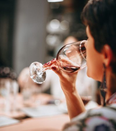 A group of adults enjoying wine together indoors in a warm social setting.