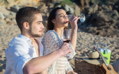 pexels-photo-7569001-7569001 Couple enjoying a picnic with red wine on a sunny beach in Portugal.